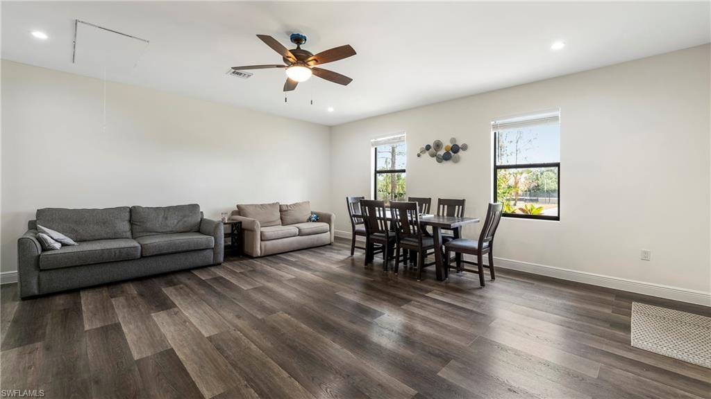 Living room featuring recessed lighting, a ceiling fan, and dark wood-style floors