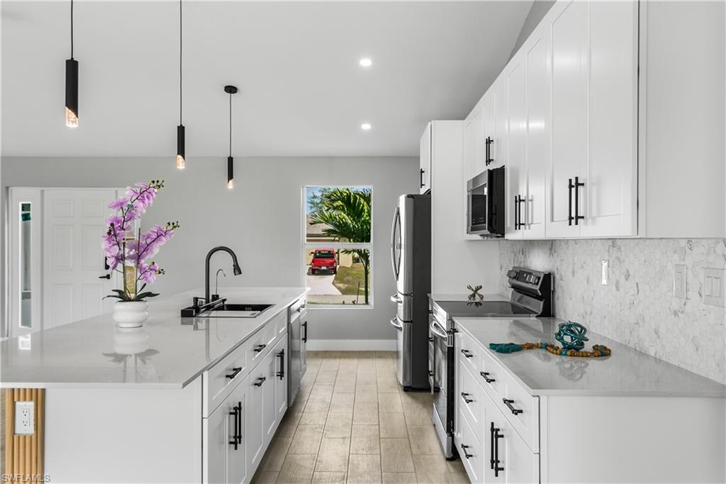 A commercial-style matte black pull-out faucet with pot filler functionality, undermount sink, and sleek finishes elevate both design and performance.
