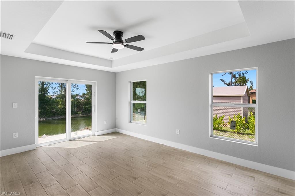 Retreat to the spacious primary suite featuring sliding doors to the lanai & a walk-in closet