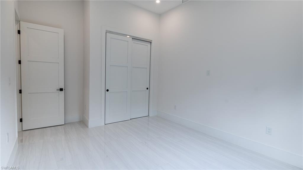 Light-toned flooring in a polished finish, white walls, and bright overhead lighting