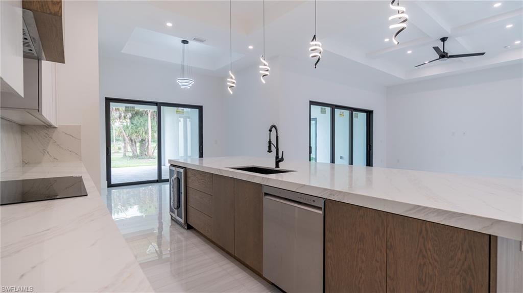 Modern kitchen island featuring a waterfall countertop with integrated sink and matte black faucet