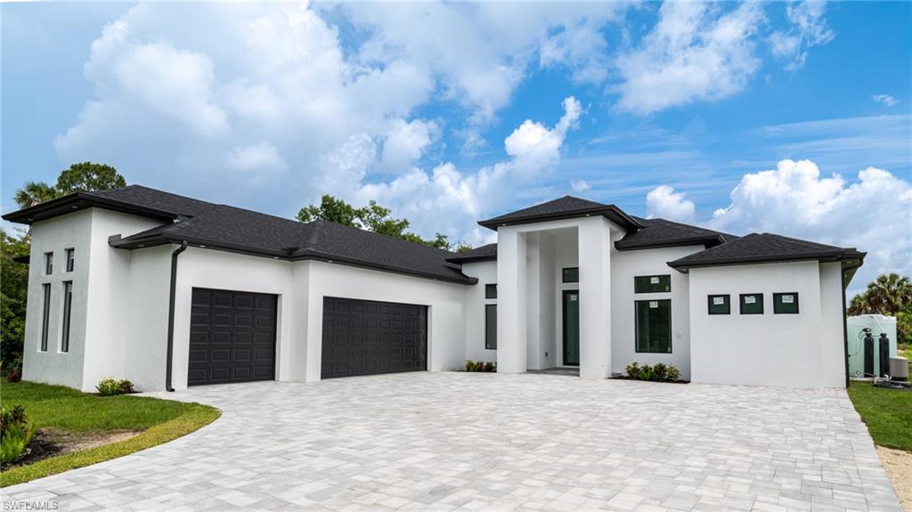 Modern stucco exterior with a prominent covered entry, black roof, and dark-framed windows