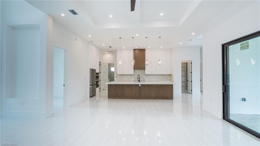 Expansive open-concept kitchen and living area featuring high ceilings with recessed lighting