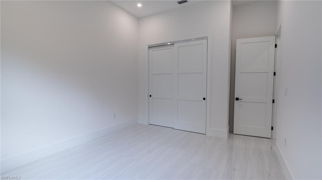 Spacious room featuring light-toned flooring and white walls