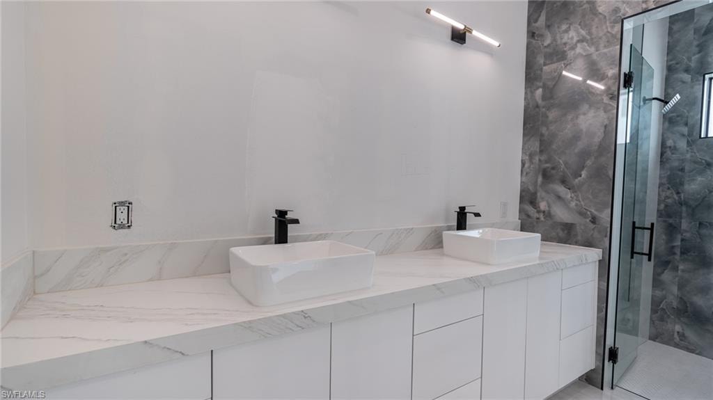 Double vanity featuring white slab-front cabinetry and a white countertop with subtle veining
