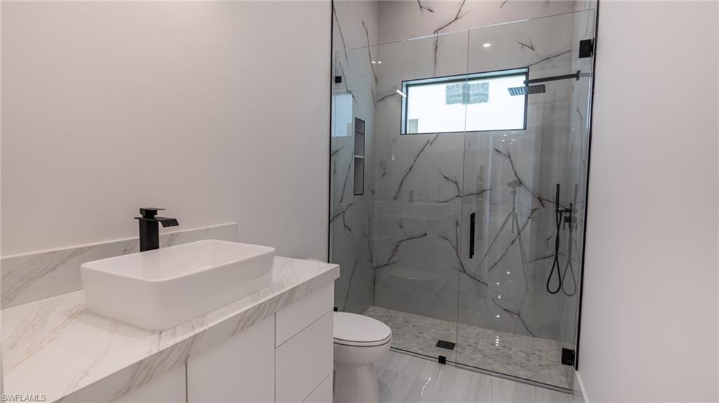 Modern bathroom featuring a glass-enclosed shower with a rectangular window and built-in niche