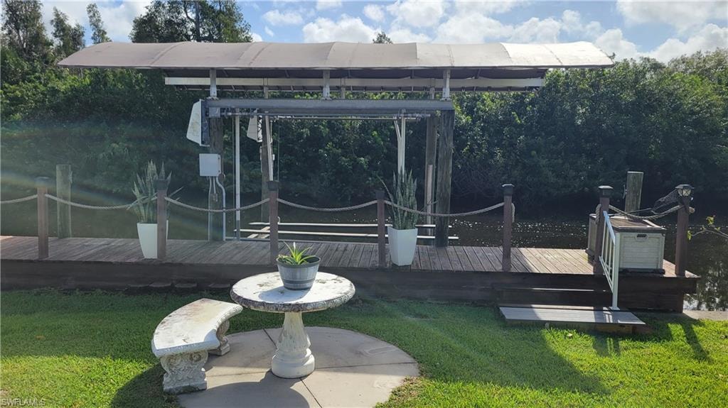 Dock with lift and cover at the rear of the home looking at canal.