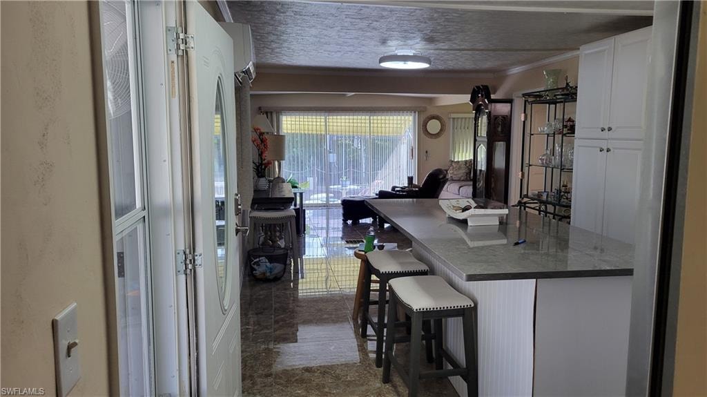 View of partial kitchen from hall with beautiful island