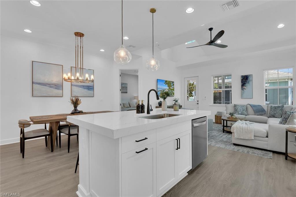 Kitchen with open floor plan, stainless steel dishwasher, a sink, and visible vents