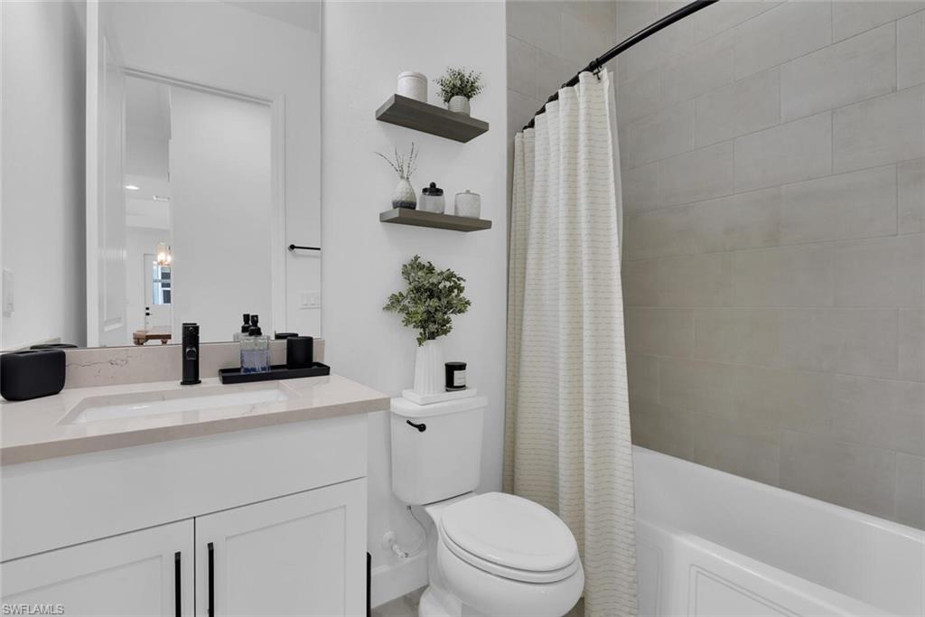 Full bath with toilet, shower / bath combo, and vanity