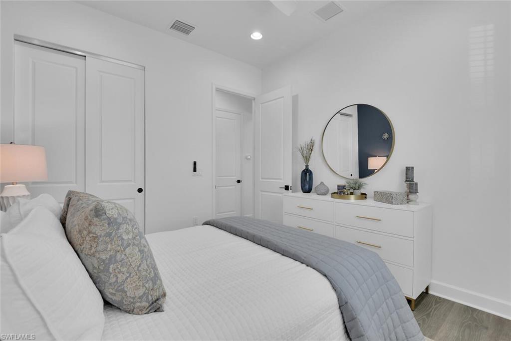 Bedroom featuring wood finished floors, baseboards, a closet, and visible vents