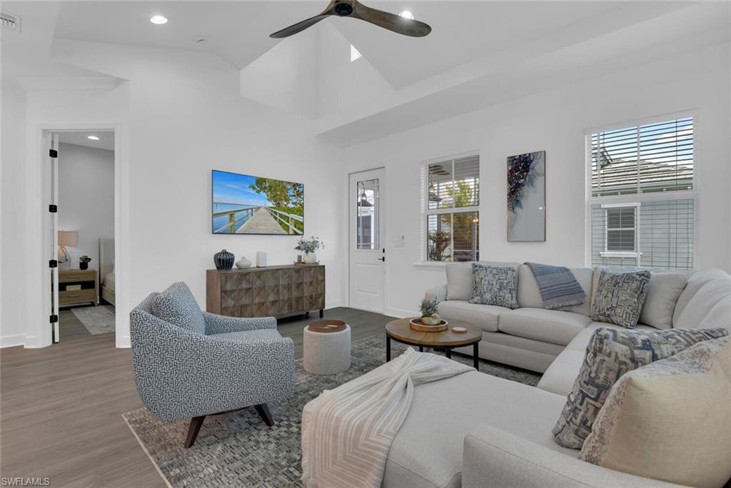 Living area featuring visible vents, ceiling fan, baseboards, and wood finished floors