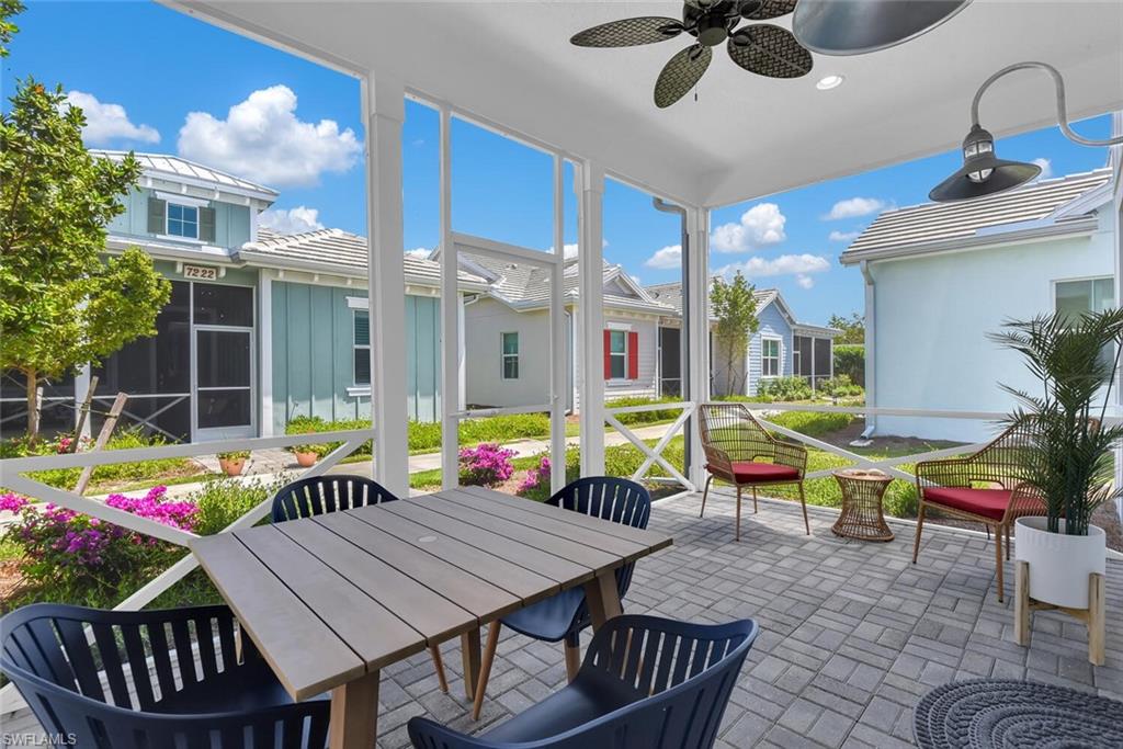 Sunroom / solarium with outdoor dining space, a residential view, and a ceiling fan