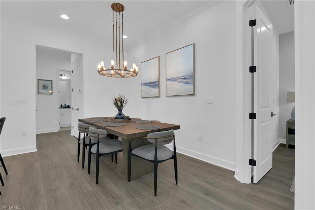 Dining space with baseboards, a notable chandelier, dark wood-style floors, crown molding, and recessed lighting