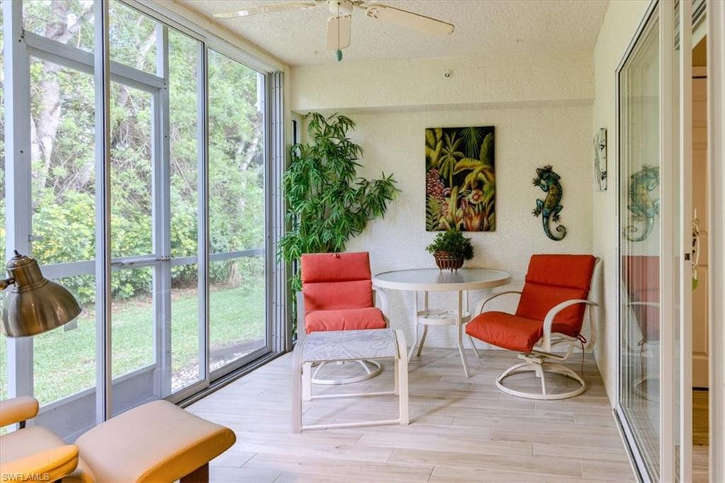 Sunroom featuring wood finished floors, a textured ceiling, and floor to ceiling windows