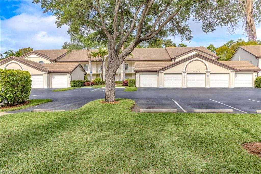 Ranch-style home featuring community garages, a front yard, and stucco siding