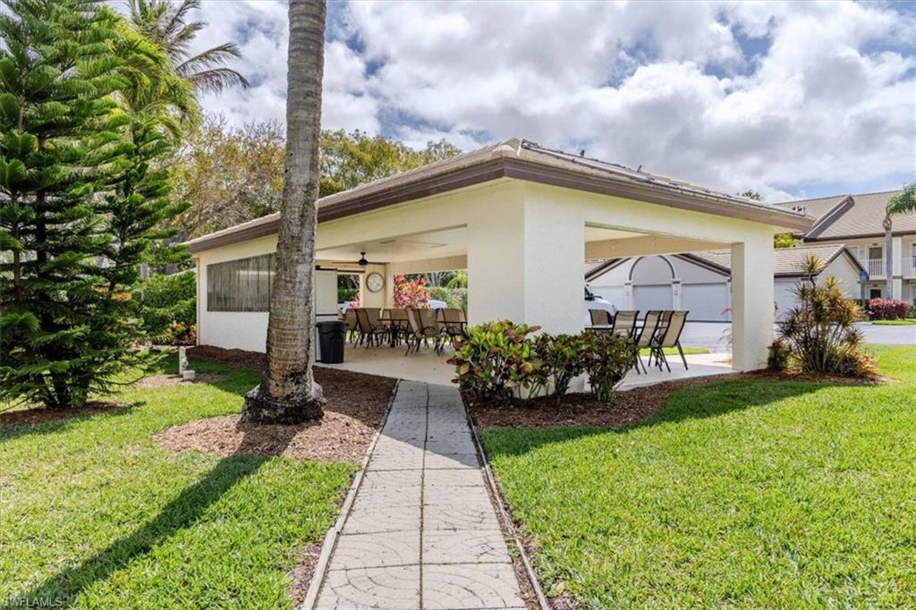 Back of property with a patio area, a ceiling fan, a yard, stucco siding, and outdoor dining space