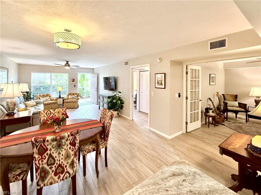 Dining area featuring ceiling fan, light wood-type flooring, and a textured ceiling