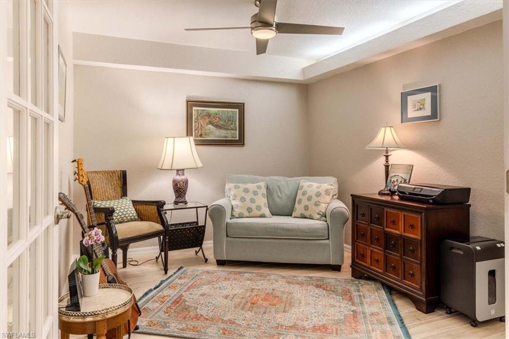 Living area with light wood-style floors and a ceiling fan