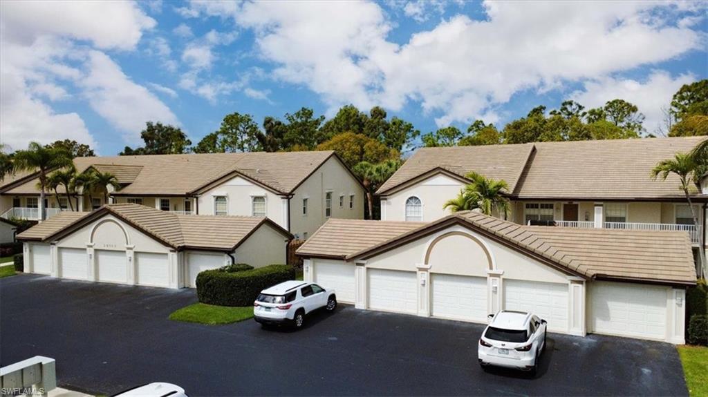 View of front of home featuring community garages, a residential view, and stucco siding