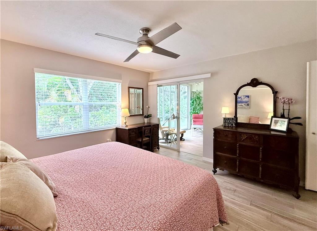 Bedroom featuring light wood-style floors, access to exterior, and a ceiling fan