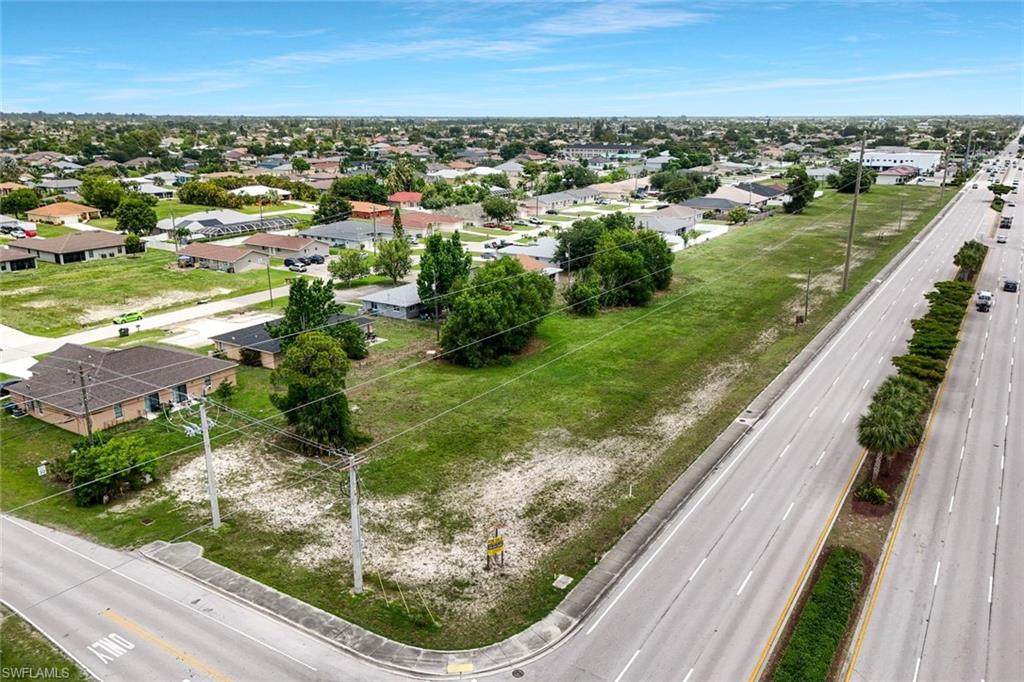 Expansive land parcel featuring a main road frontage, adjacent neighborhood, and clear, level terrain