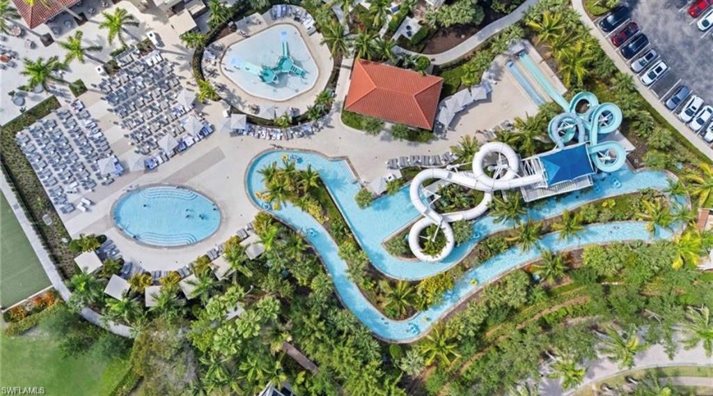 Aerial view of the property's amenities, featuring a swimming pool, a water park with slides, a lazy river, and extensive lounge areas with umbrellas