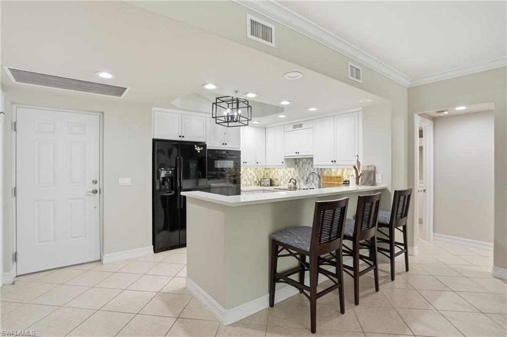 The living area features tile flooring, crown molding, and direct access to a private balcony through sliding glass doors