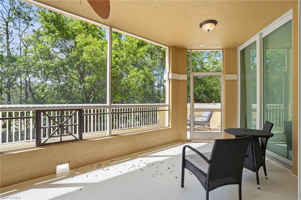 The property features a screened-in porch with a ceiling fan, offering views of mature trees