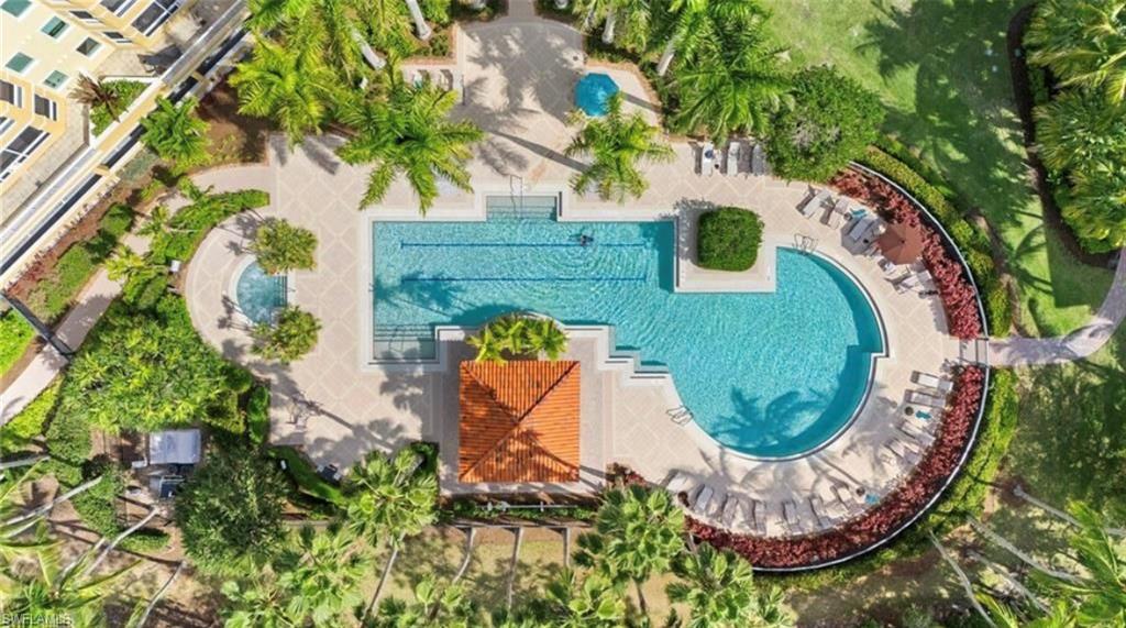 Aerial view highlighting the property's resort-style swimming pool area, surrounded by lush green landscaping and mature palm trees