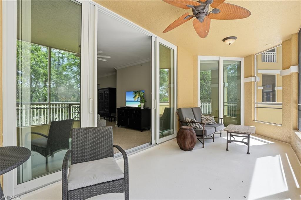 Expansive screened-in porch with a ceiling fan, offering a comfortable outdoor living space