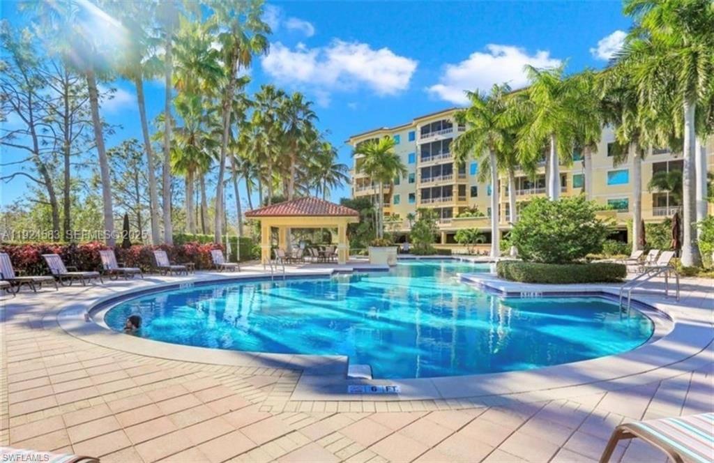 The property features a large outdoor swimming pool surrounded by a paved deck with lounge chairs