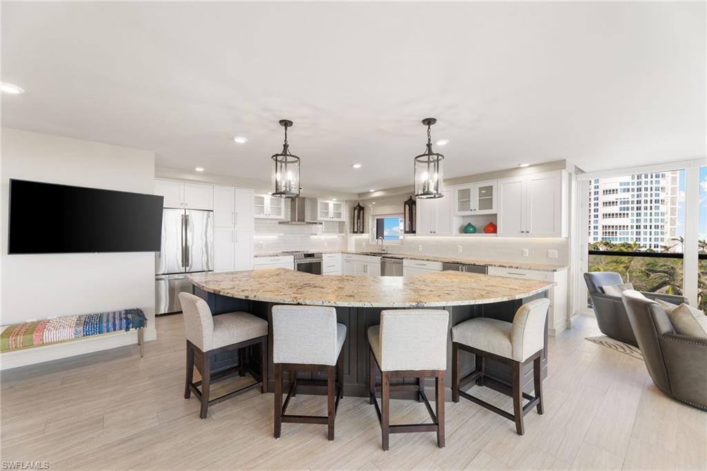 Kitchen with stainless steel appliances, white cabinetry, glass insert cabinets, tasteful backsplash, and a sink