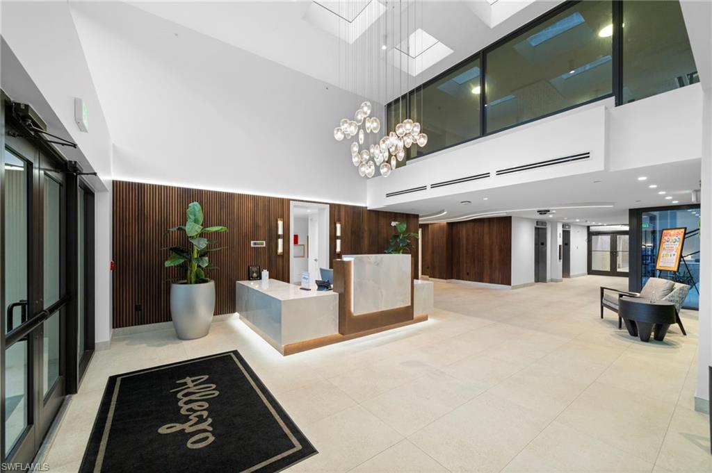 Reception area with a high ceiling, a skylight, wooden walls, and a chandelier