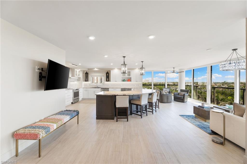 Living area featuring light wood-style flooring, recessed lighting, expansive windows, and a chandelier