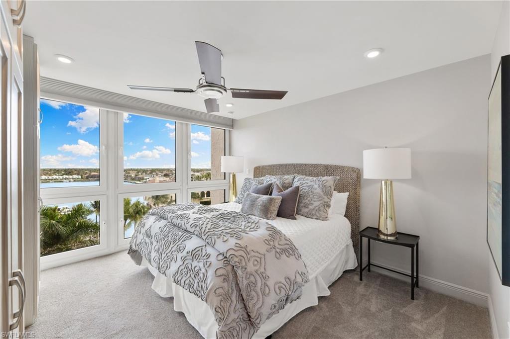 Carpeted bedroom featuring recessed lighting, a water view, a ceiling fan, and baseboards