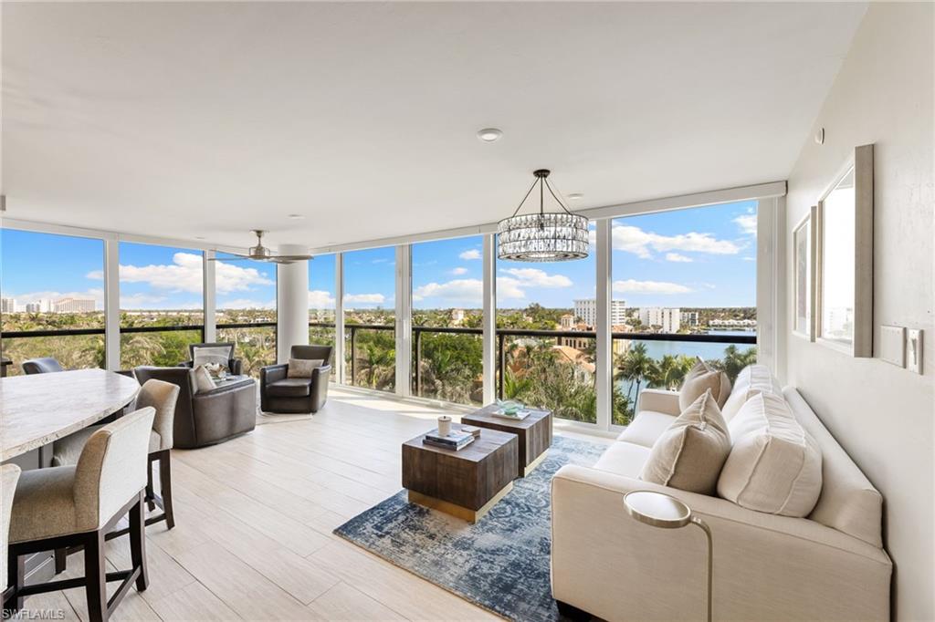 Living area with a chandelier, expansive windows, and light wood-style floors