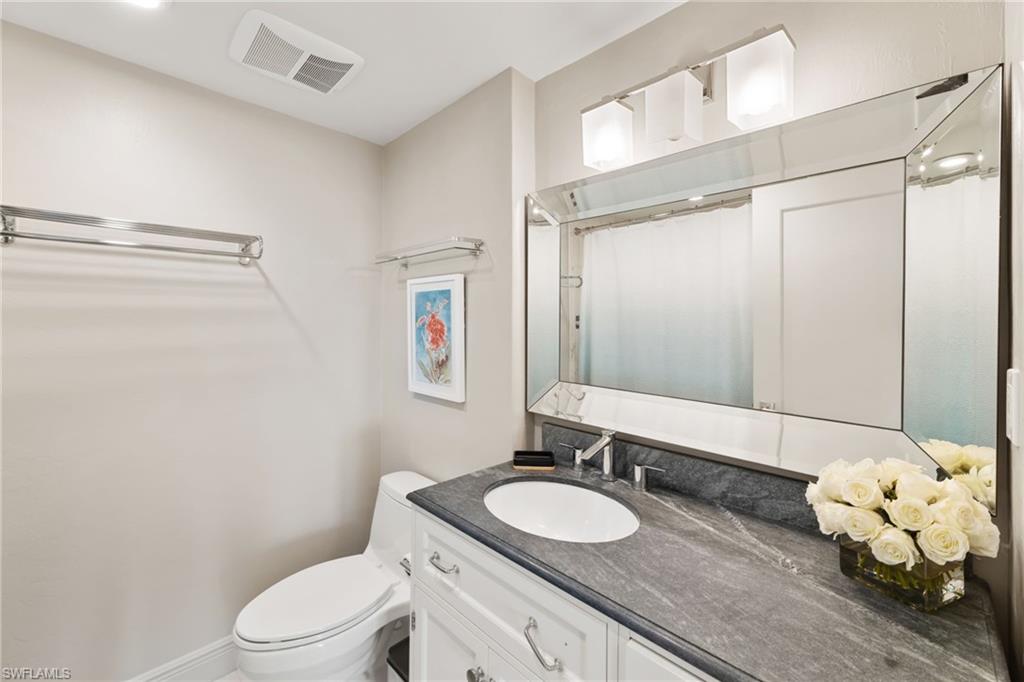 Full bath with toilet, vanity, and a shower with curtain