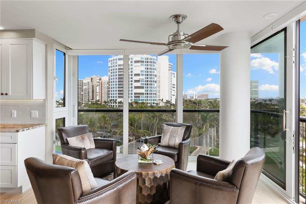 Sunroom / solarium with a city view, wood finished floors, and expansive windows