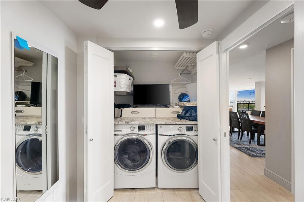 Washroom featuring washer and dryer, a ceiling fan, light wood finished floors, and recessed lighting