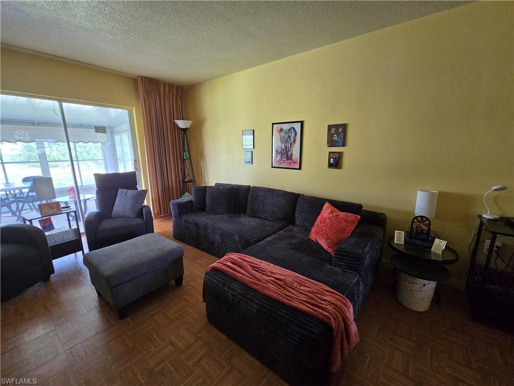 The nice sized living room with sliders to the sun room provide lots of natural light and a great view.