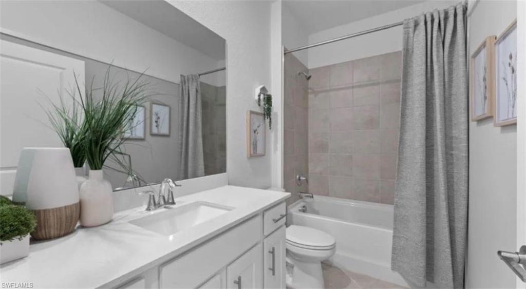 Full bathroom with vanity, shower / tub combo, and light tile patterned floors
