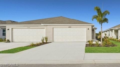 View of front of property with a garage, concrete driveway, and stucco siding