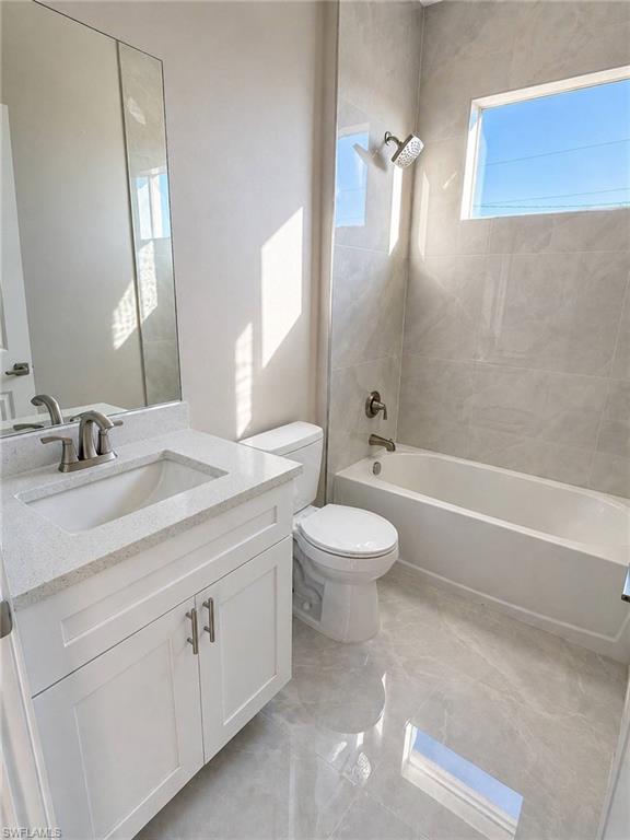 Contemporary bathroom featuring a white vanity with a quartz countertop, an undermount sink, and brushed nickel fixtures