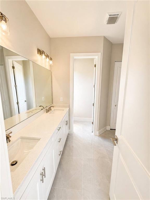 Double vanity featuring white cabinetry, quartz countertops, and dual undermount sinks