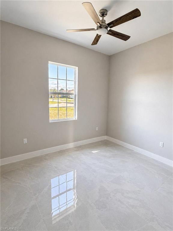 Room featuring light gray wall paint, large format tile flooring, a multi-pane window, and a ceiling fan with integrated lighting