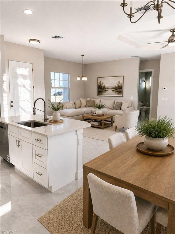 Open-concept living area featuring a kitchen island with quartz countertops, a dining area with wood-finish table, and light tile flooring