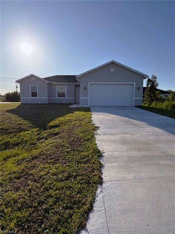 Contemporary stucco exterior with a two-car garage, concrete driveway, and covered entry