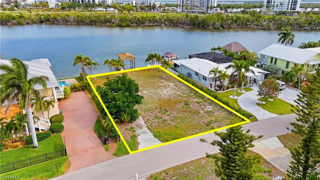 Aerial view of property's location featuring property boundaries highlighted and a nearby body of water - Virtually Edited Image