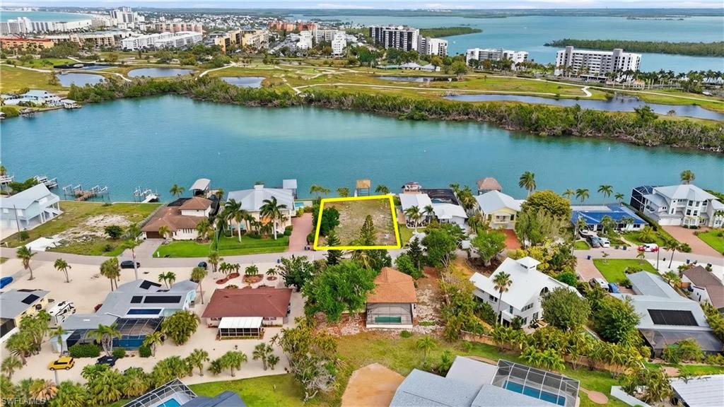 View of urban area with property boundaries highlighted and a nearby body of water - Virtually Edited Image